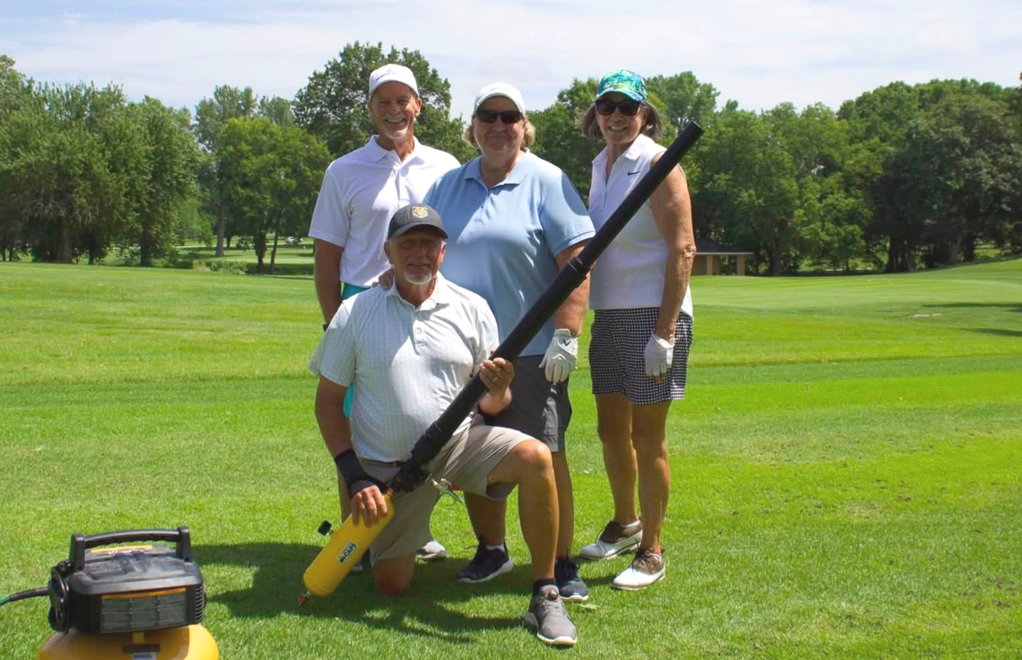 A group of men are posing for a picture on a golf course.