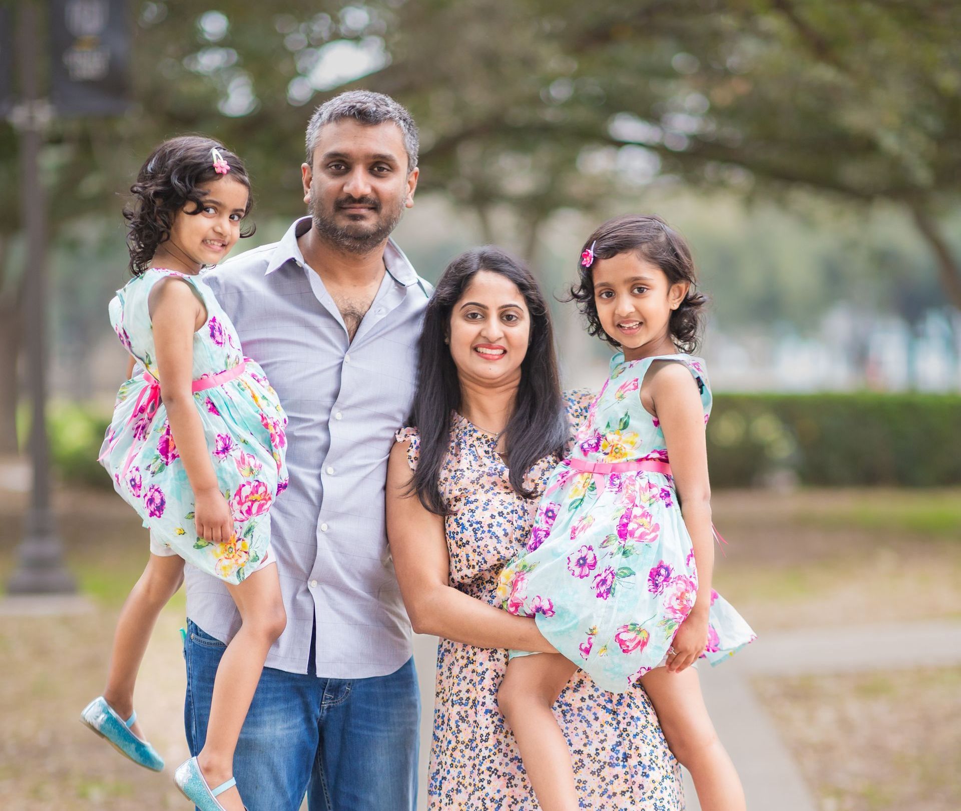 A family is posing for a picture in a park.