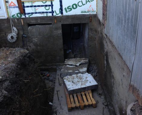 Une palette en bois est posée dans un trou à côté d'un mur.