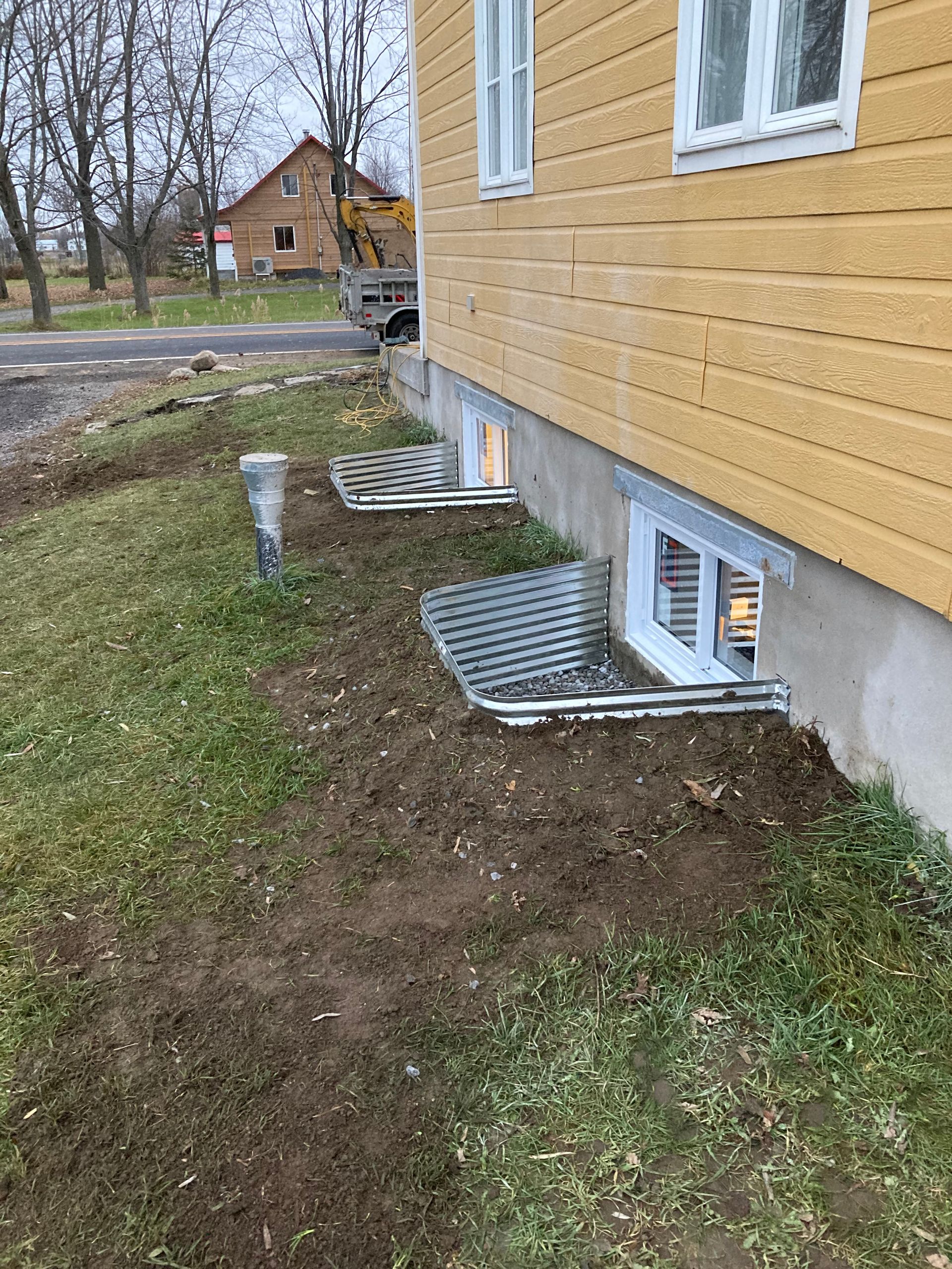 Une maison jaune avec beaucoup de fenêtres sur le côté.
