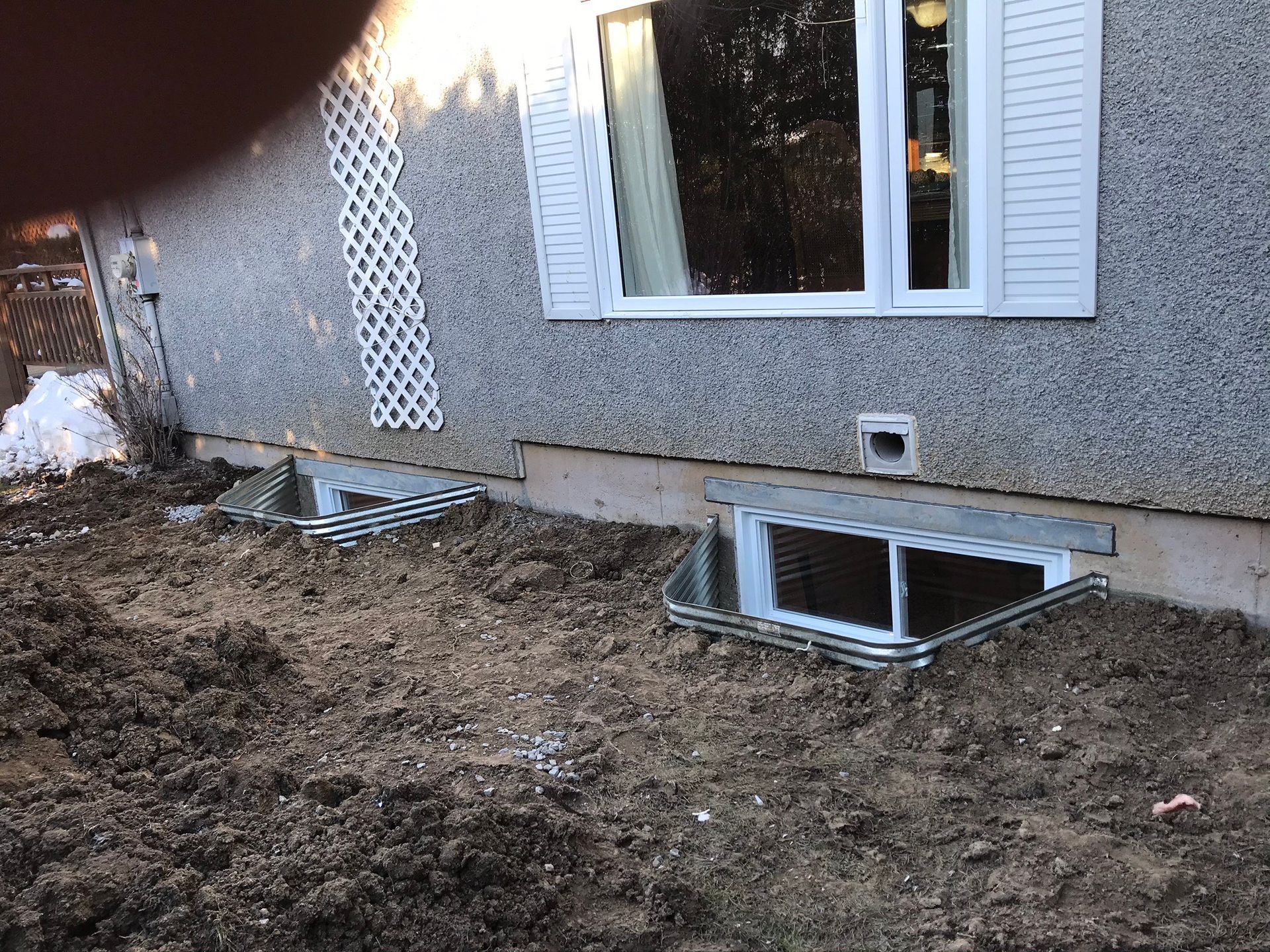 Une maison avec une fenêtre et un trou dans le sol devant.