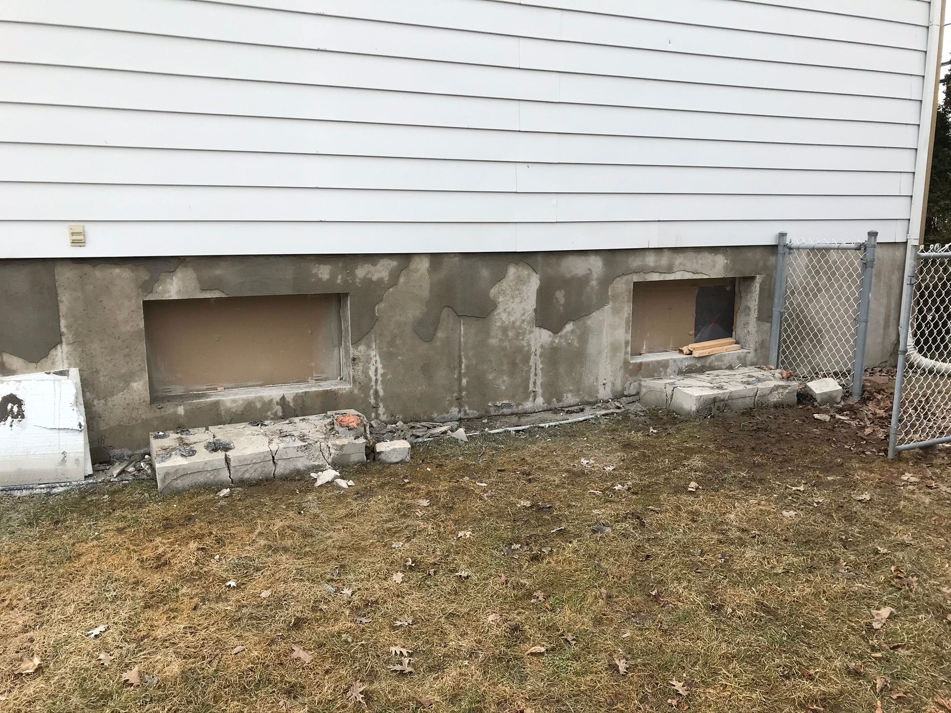 Une maison avec une clôture à mailles de chaîne devant.