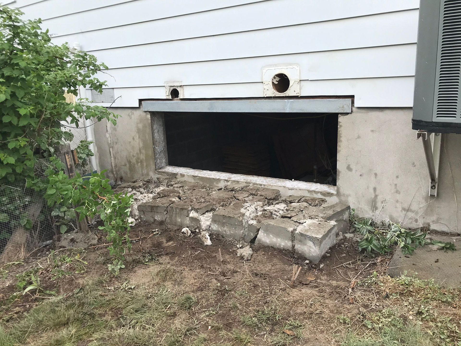 Il y a une fenêtre au sous-sol d'une maison.