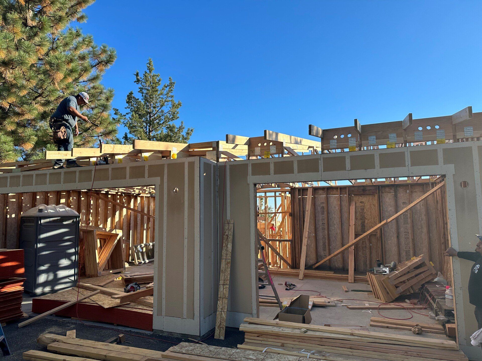 A man is working on the roof of a house under construction.