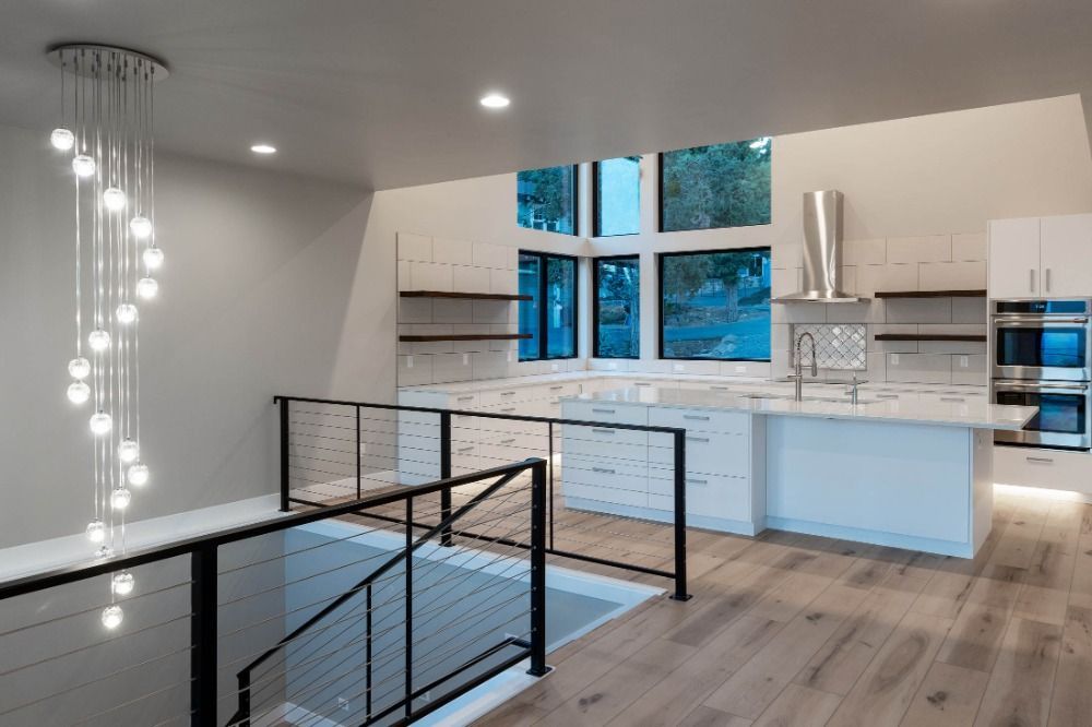 A kitchen with a staircase leading up to it and a chandelier hanging from the ceiling.