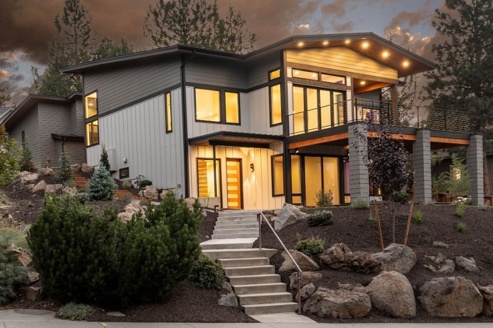 A large house with a lot of windows is sitting on top of a hill.