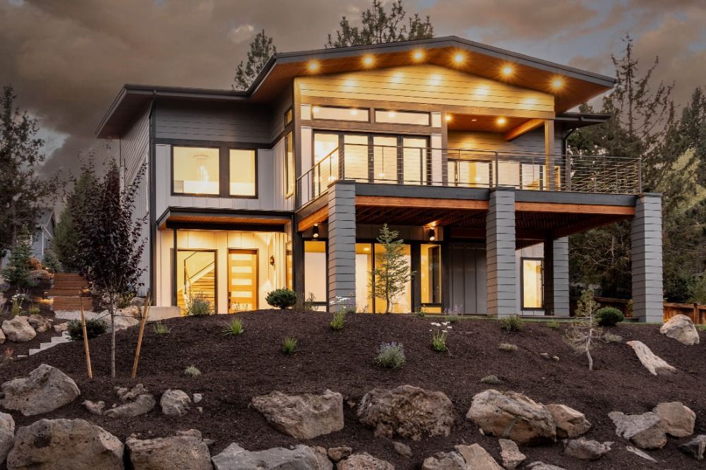 A large house is sitting on top of a rocky hill.