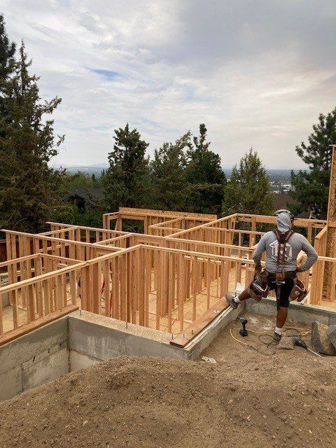 A man is standing in front of a house under construction