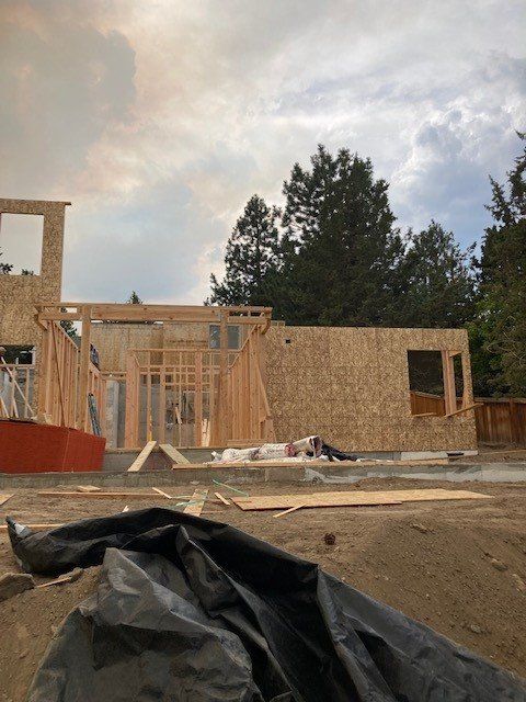 A house is being built with a black tarp in the foreground