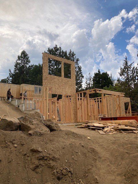 A house is being built on top of a dirt hill.