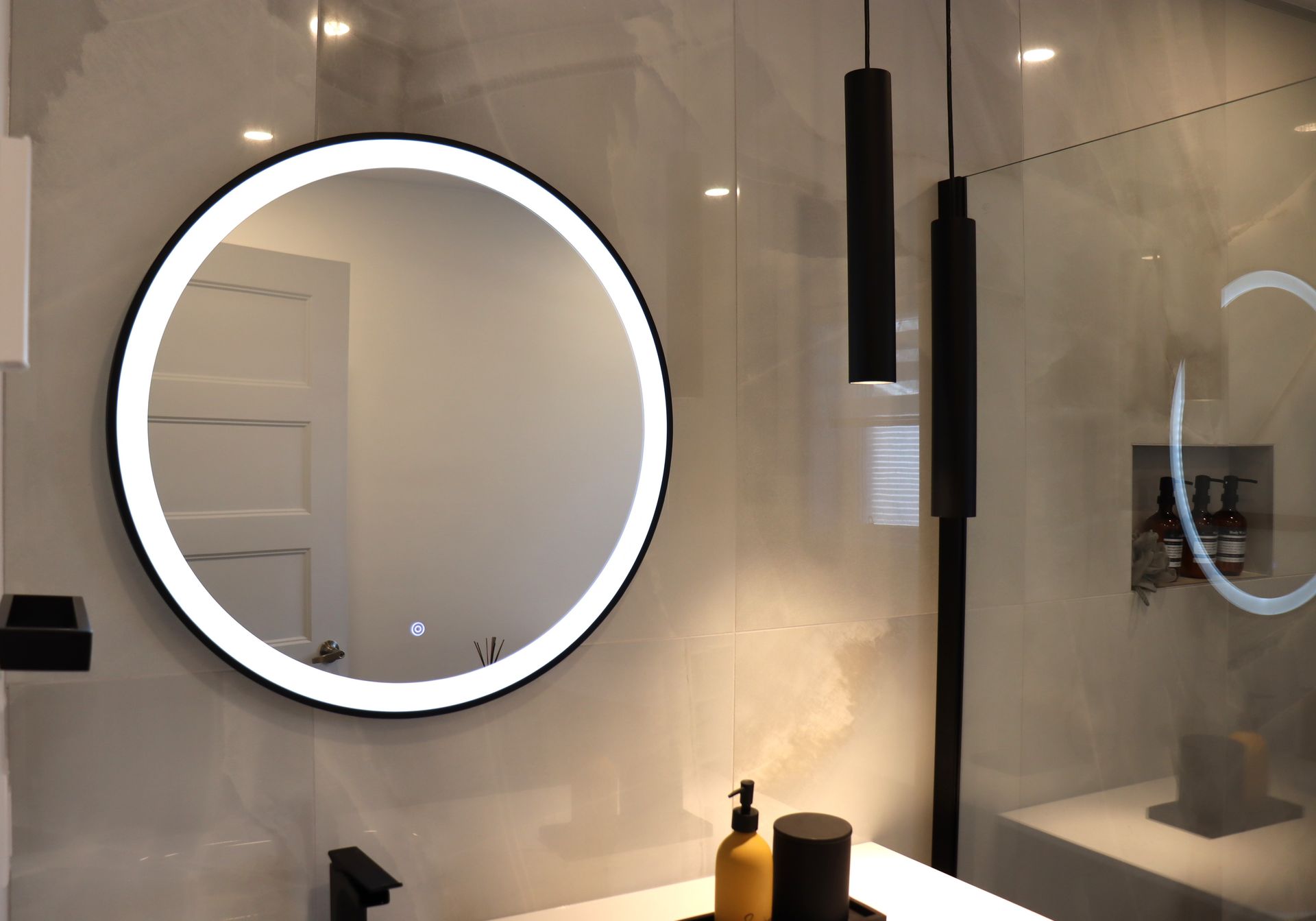 A bathroom with a round mirror and a sink.