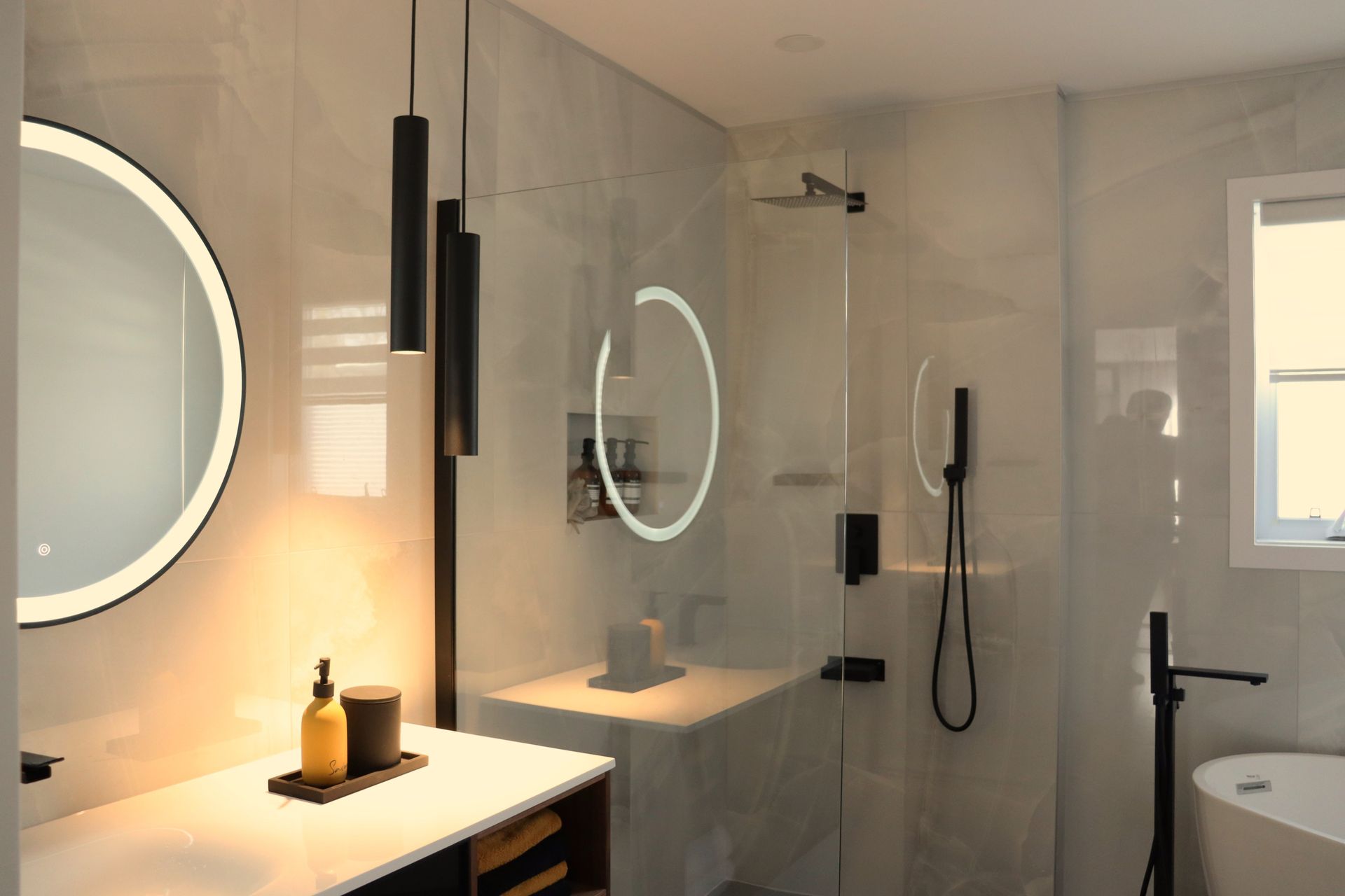 A bathroom with a tub , sink , mirror and shower.