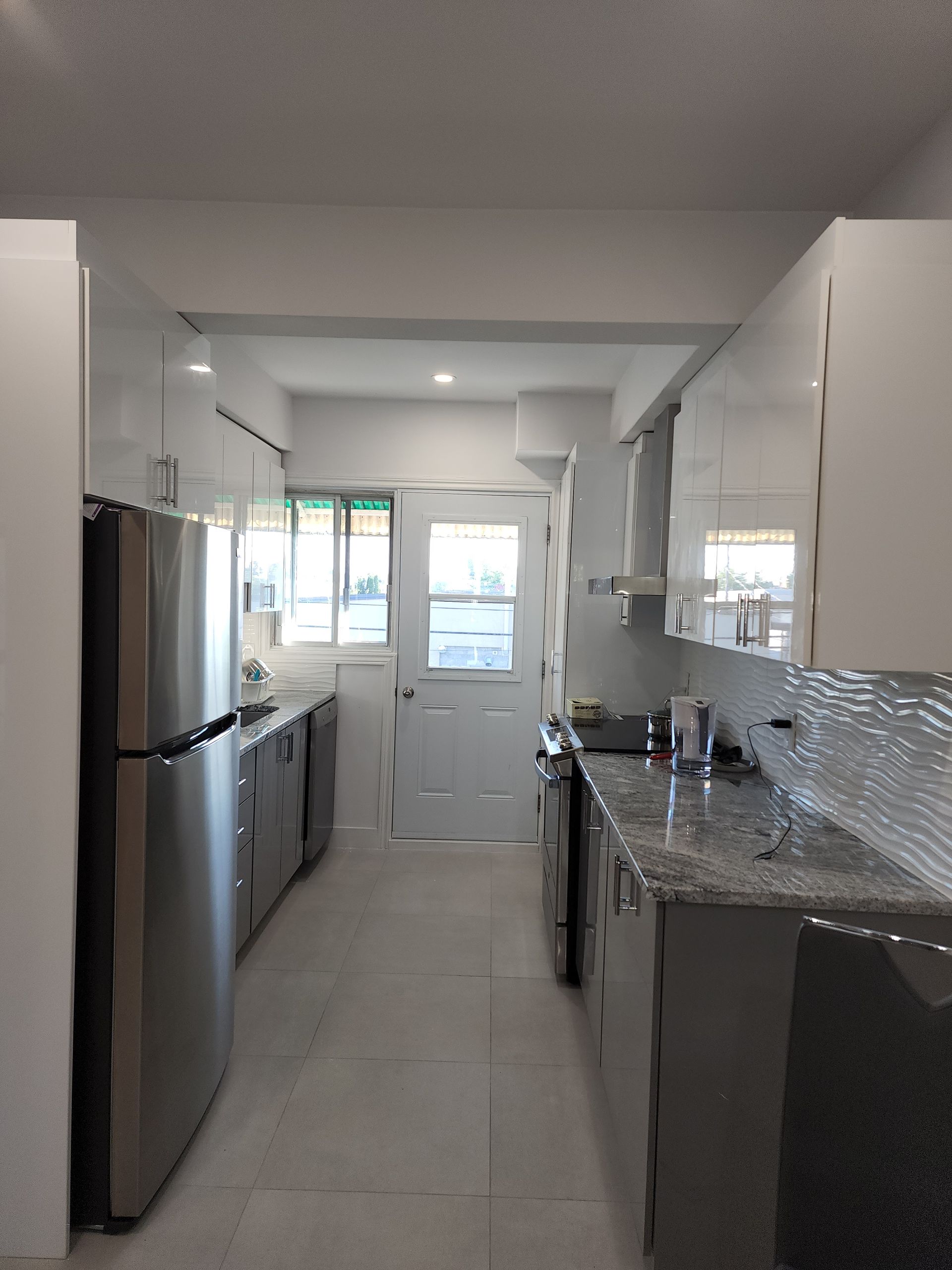 A kitchen with stainless steel appliances and white cabinets
