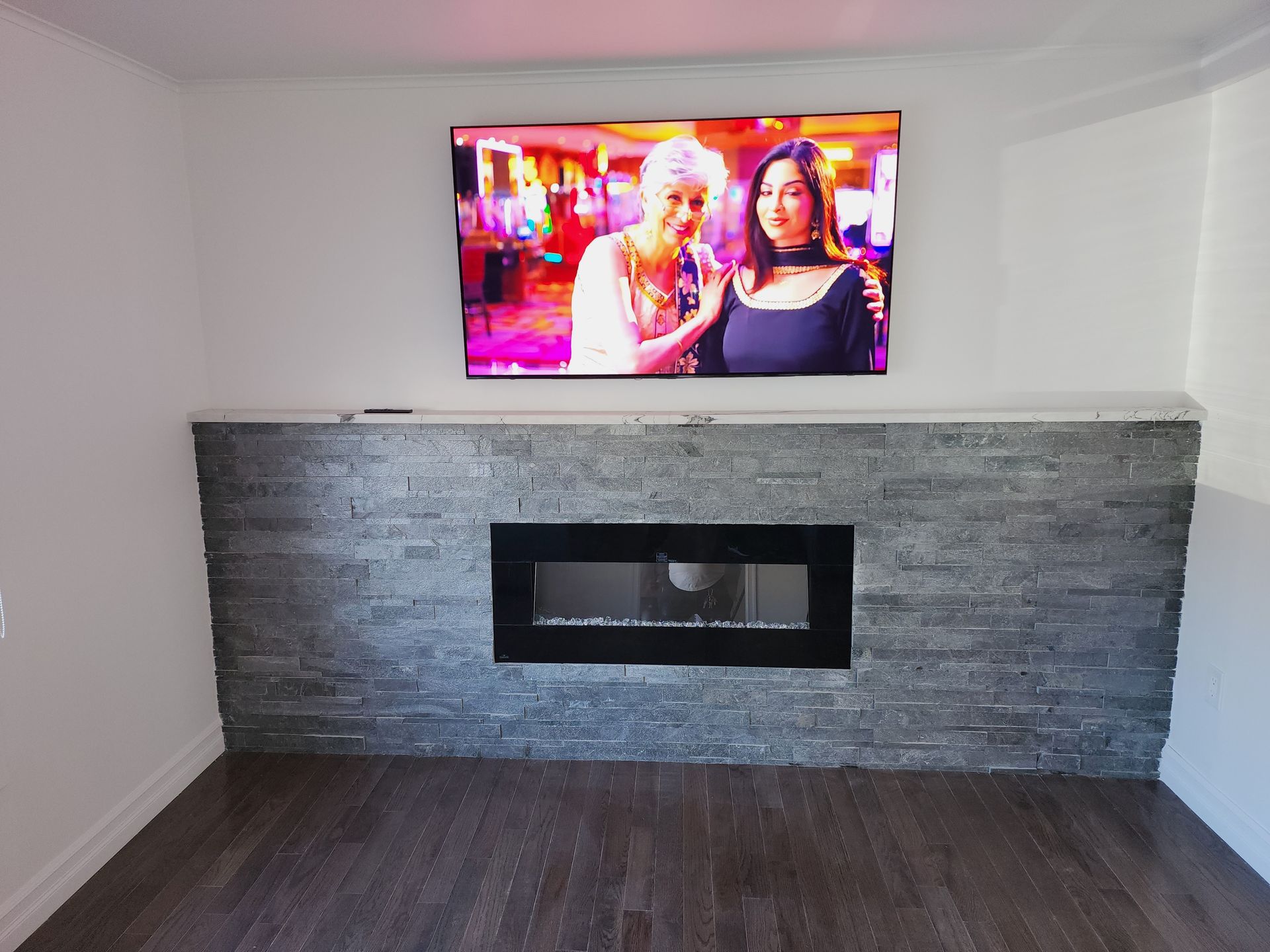 A living room with a fireplace and a flat screen tv