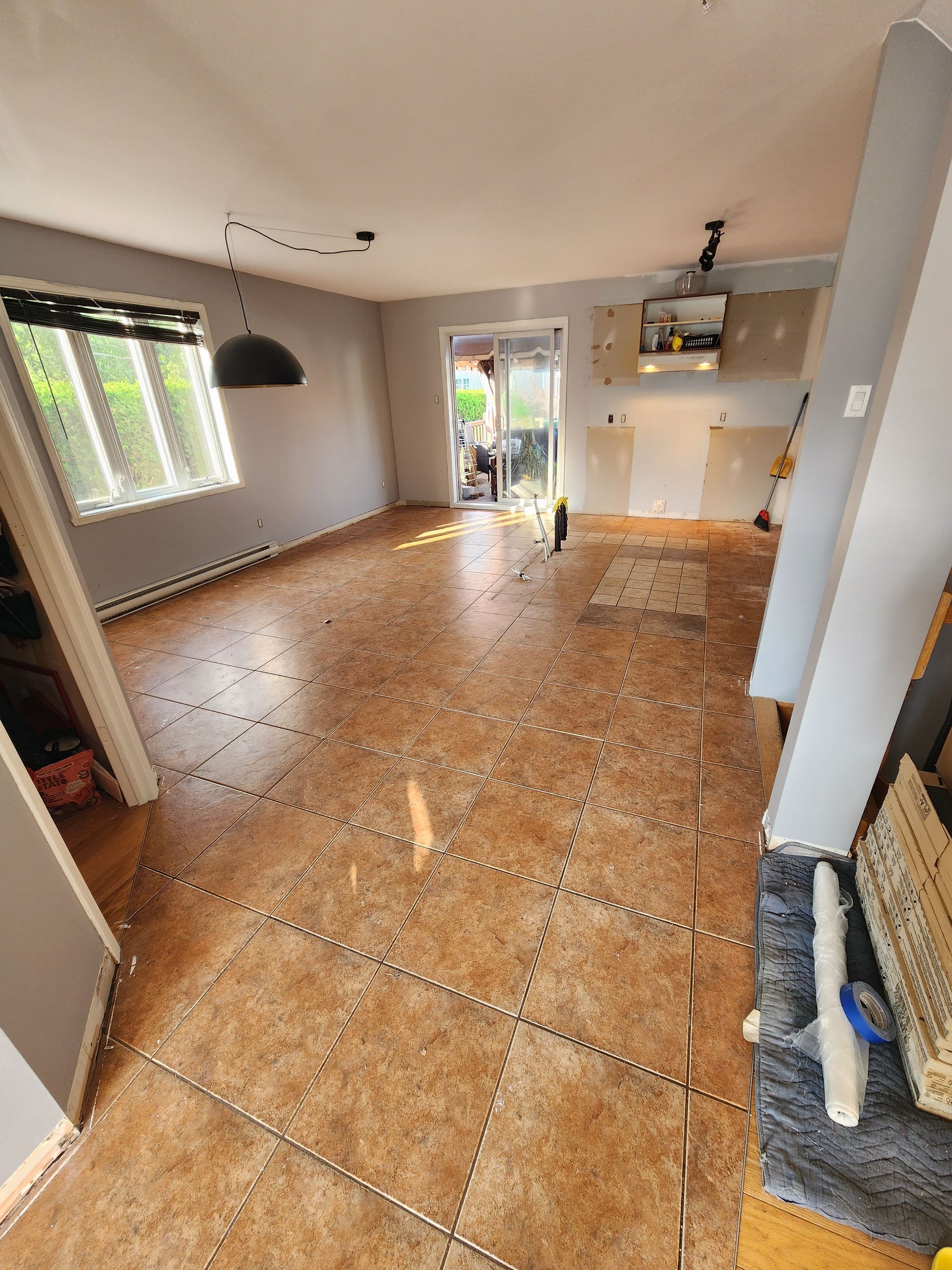 A living room with a tiled floor and a sliding glass door.