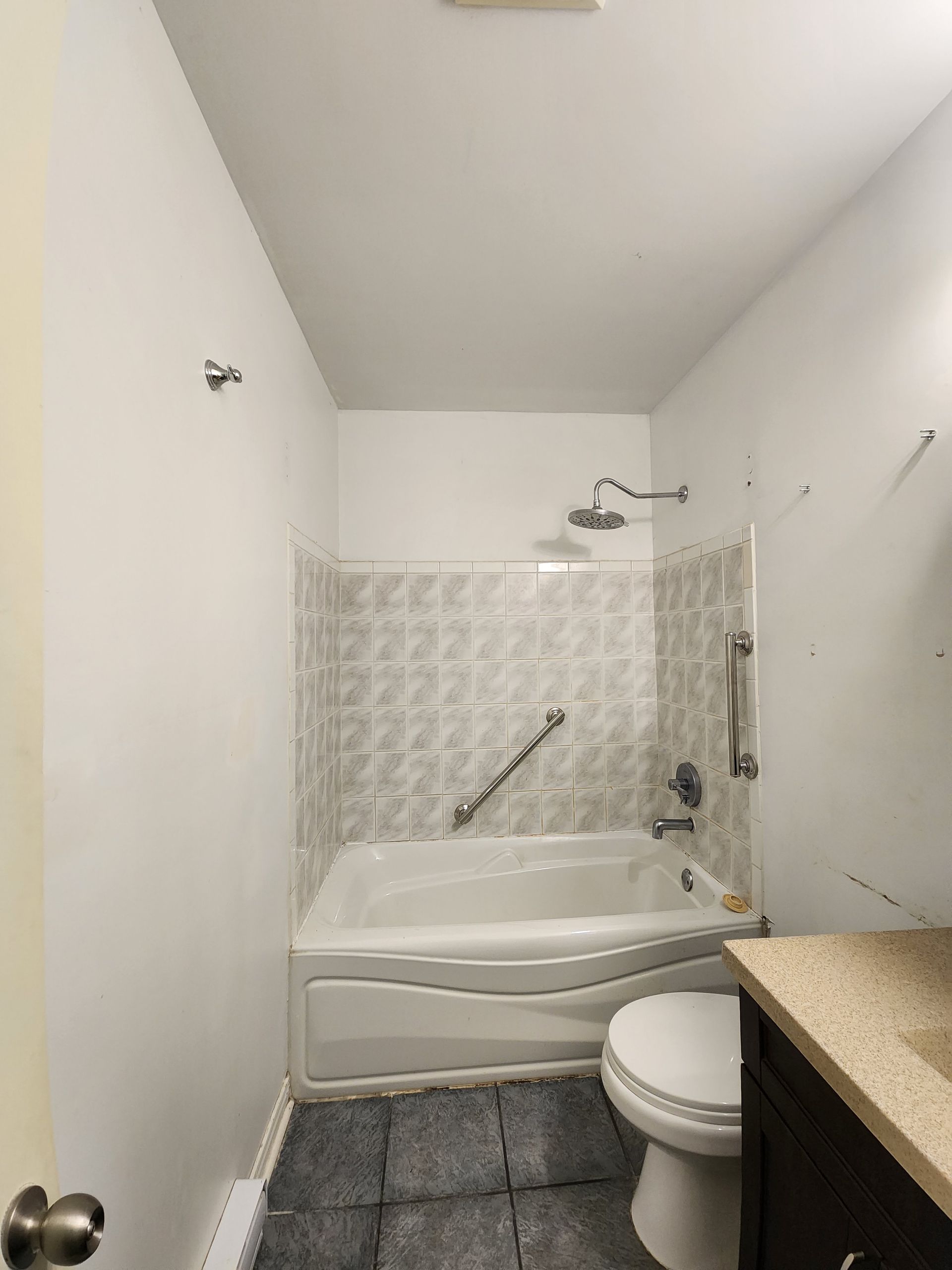 A bathroom with a tub , toilet , sink and shower.