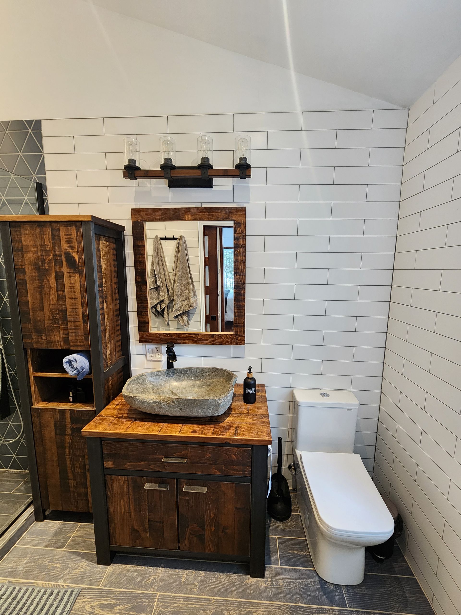 A bathroom with a sink , toilet and mirror.