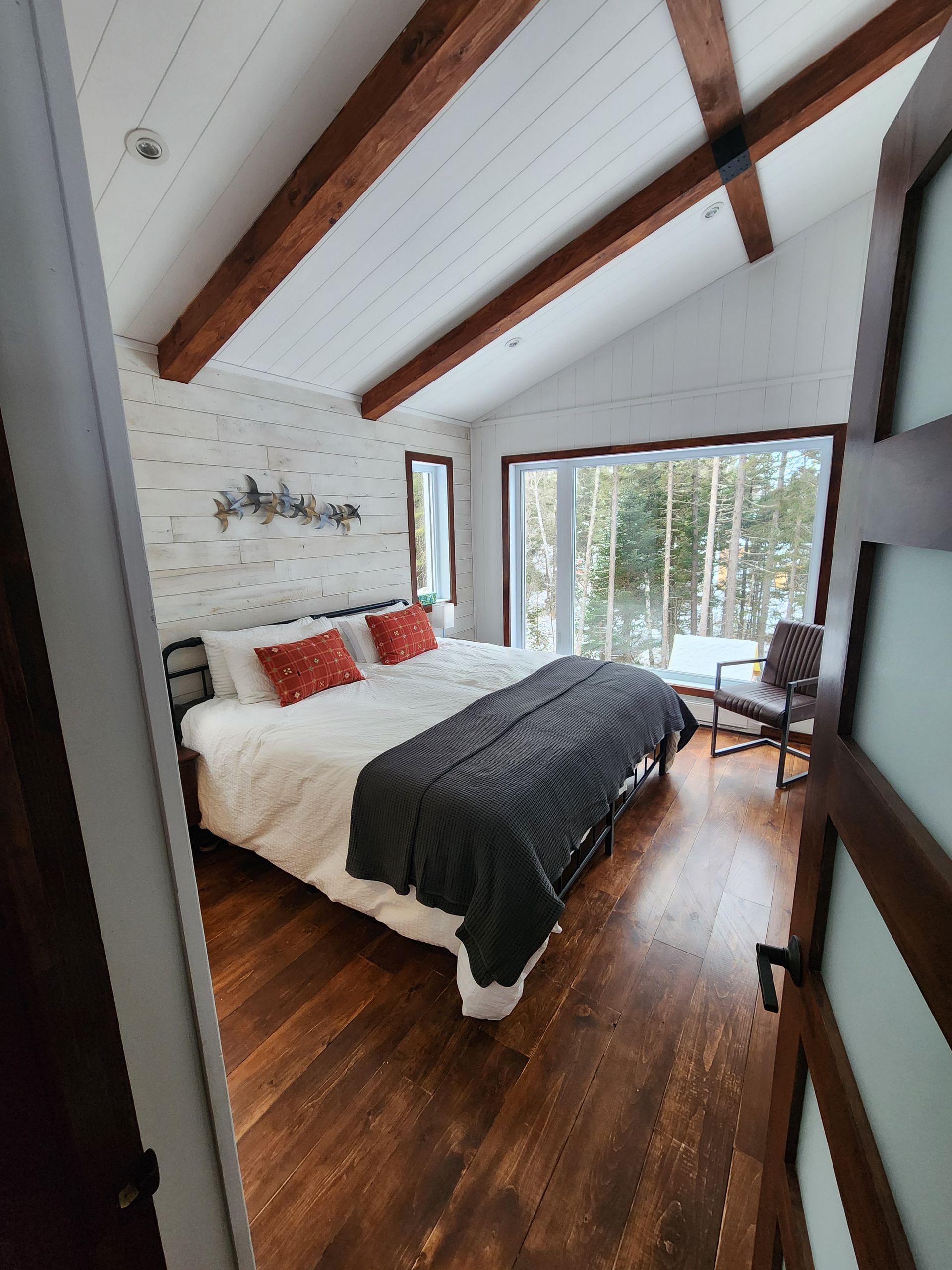 A bedroom with a large bed and a sliding glass door.
