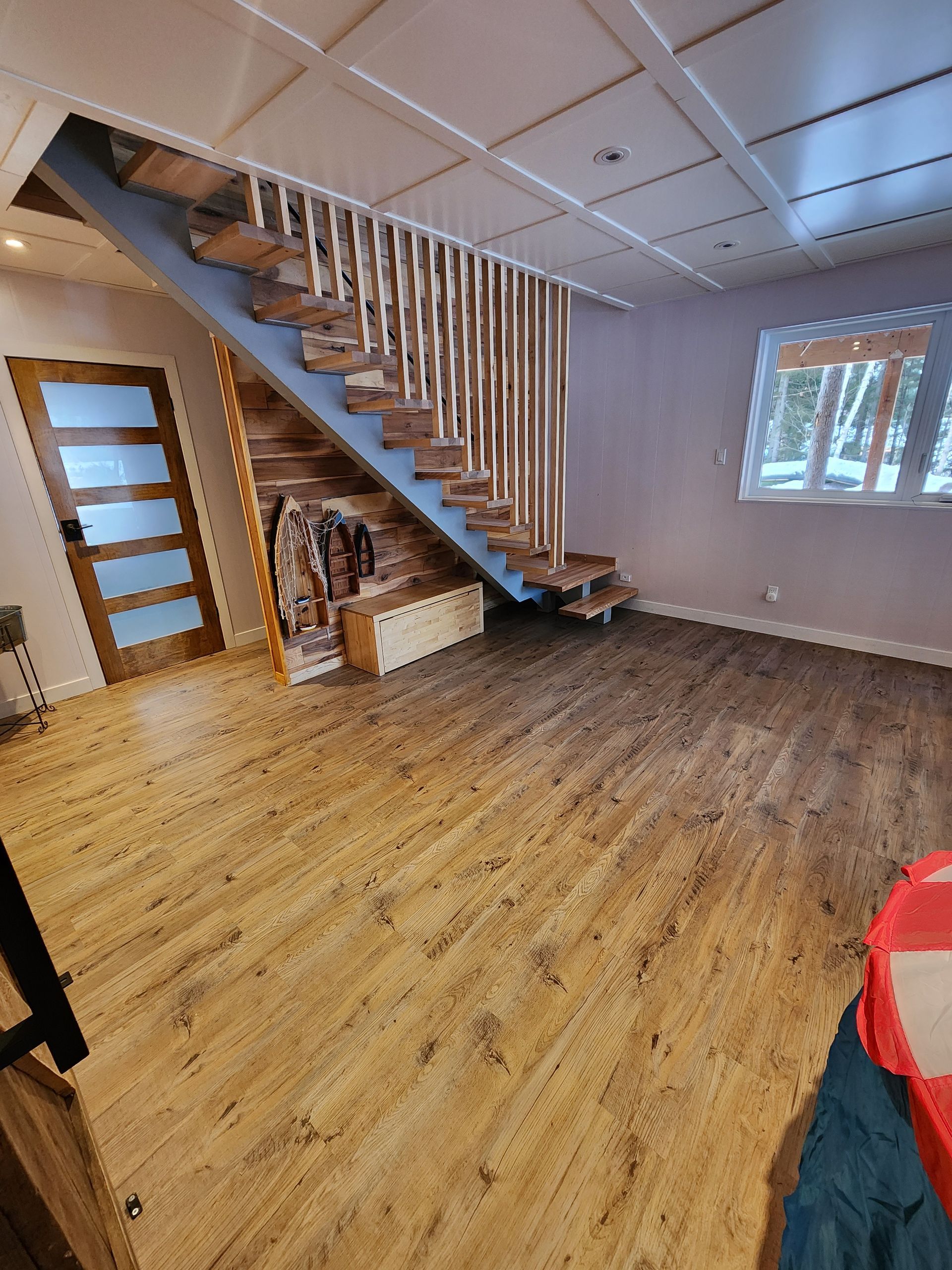 A living room with a wooden staircase and hardwood floors.
