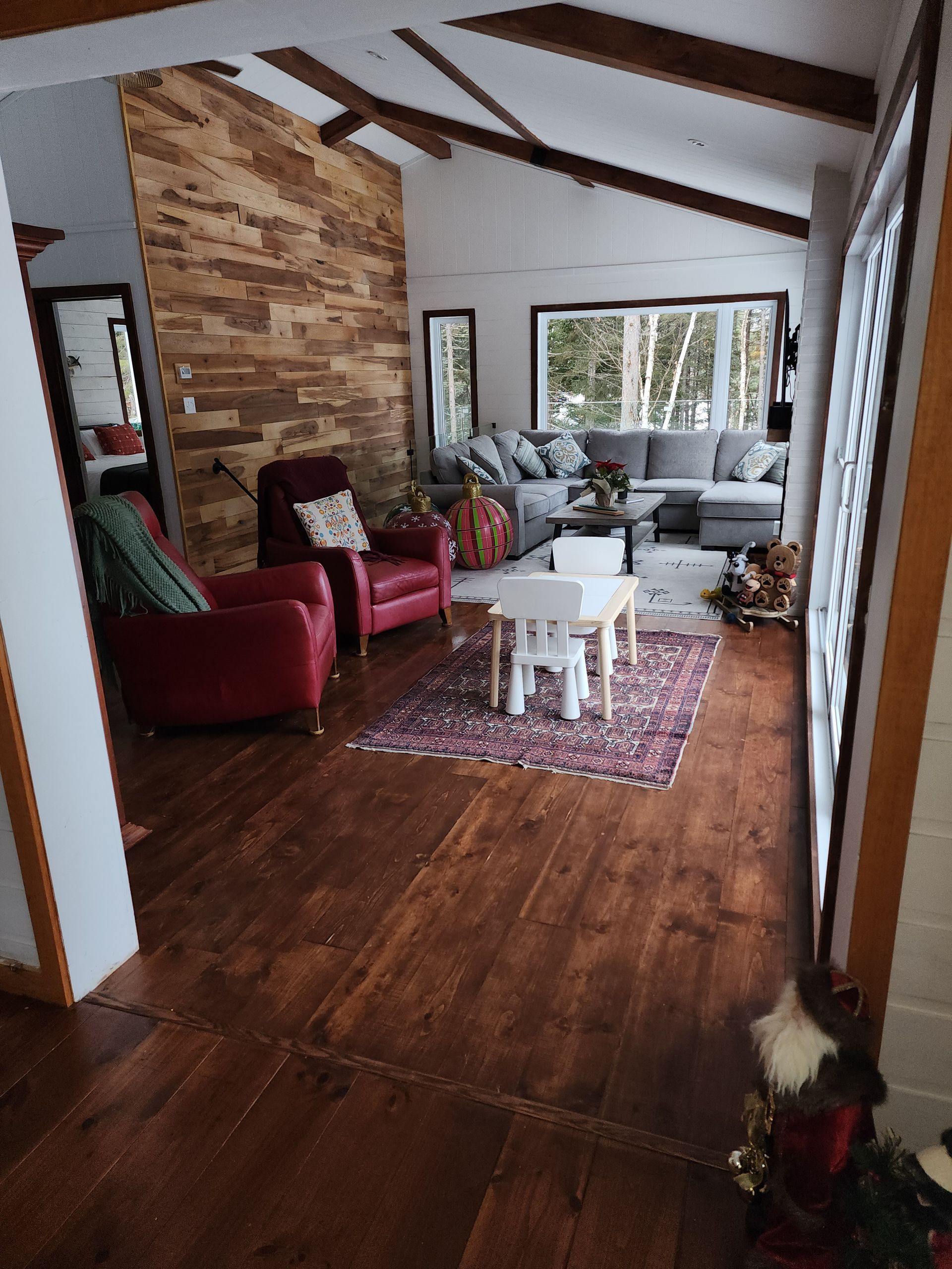 A living room filled with furniture and a wooden wall.
