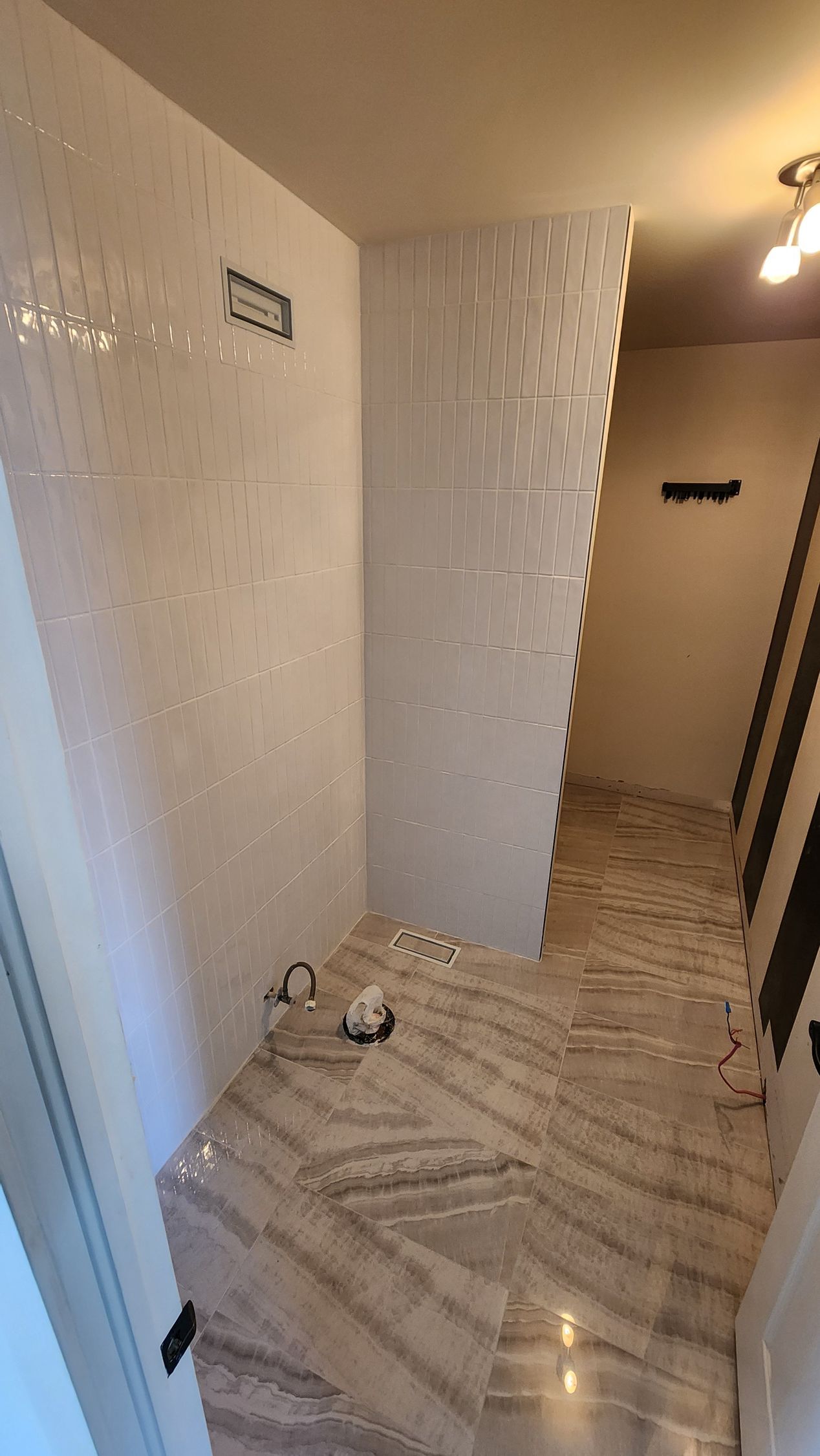 A bathroom with a walk in shower and a marble floor.