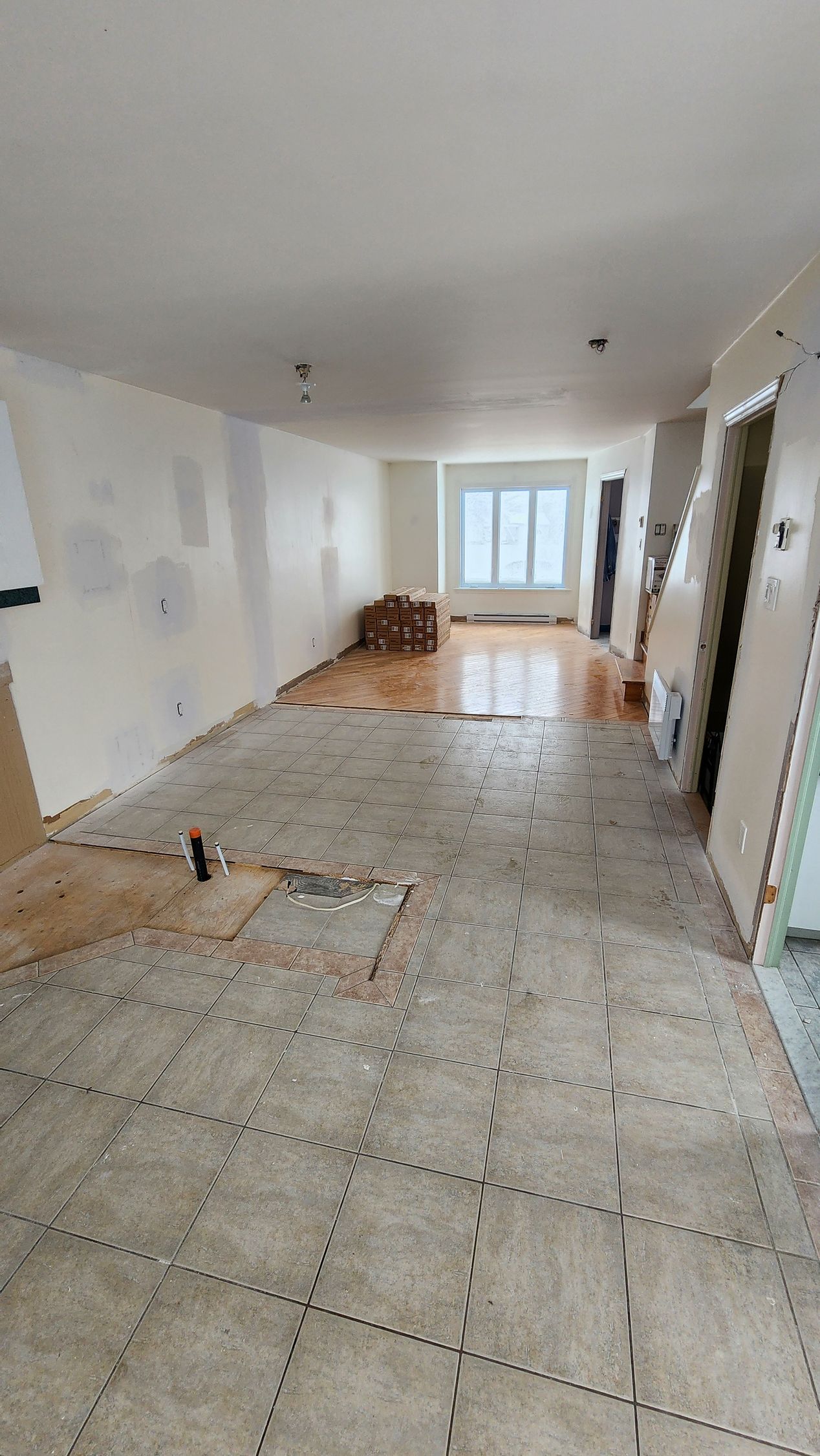 A large empty room with a tiled floor and white walls.