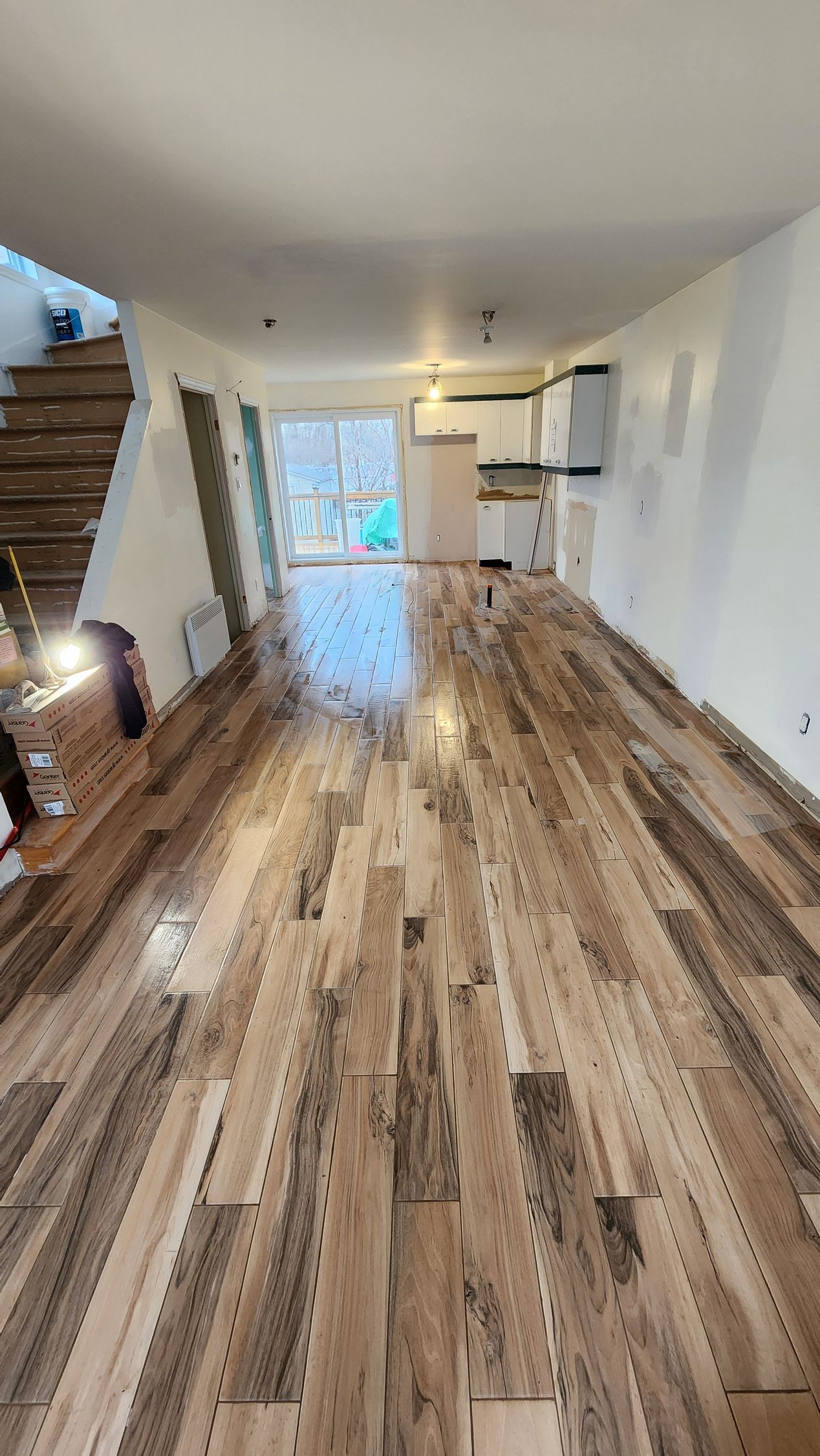 A large room with a wooden floor and stairs.