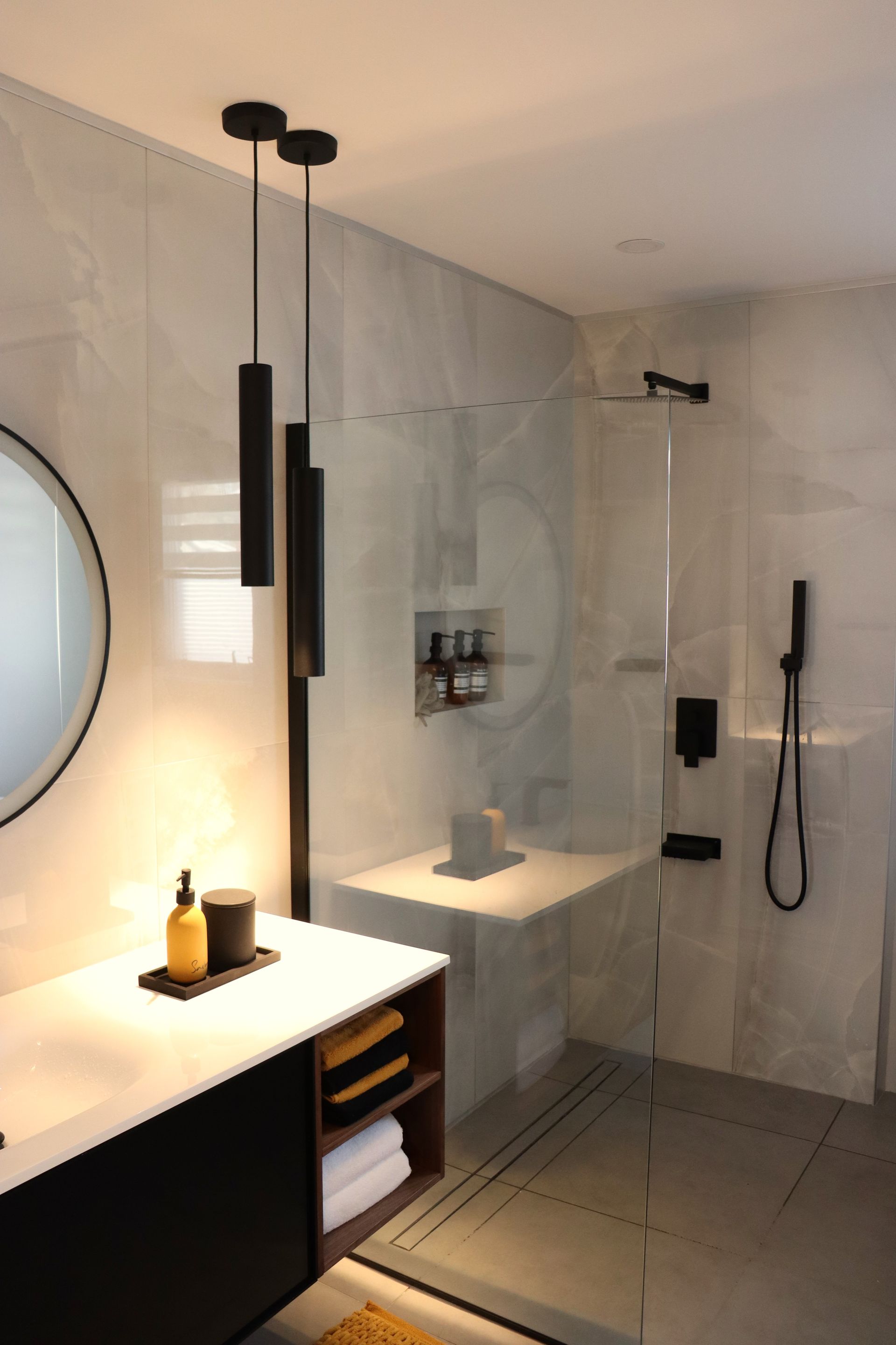 A bathroom with a walk in shower and a sink