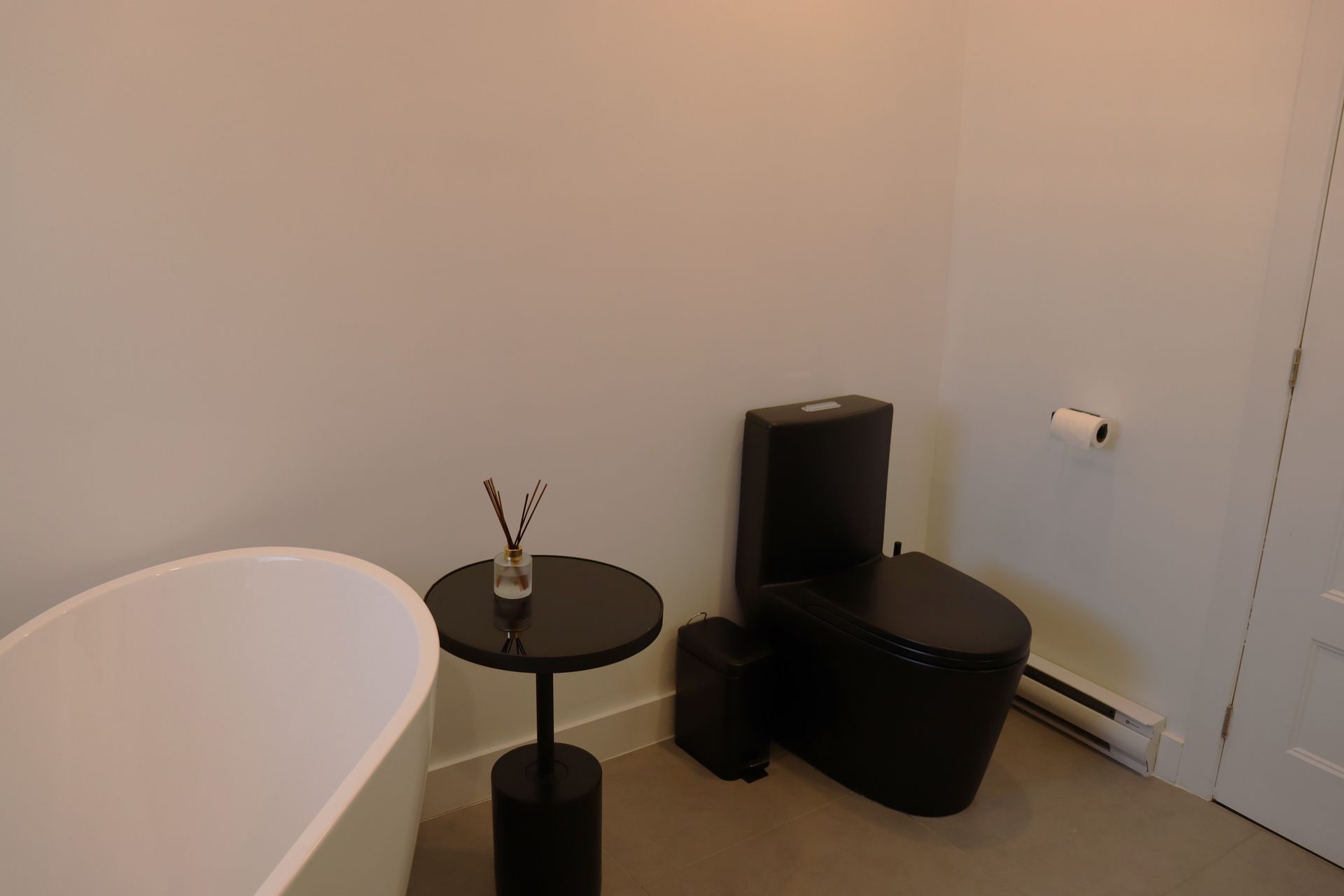 A bathroom with a tub , toilet , and table