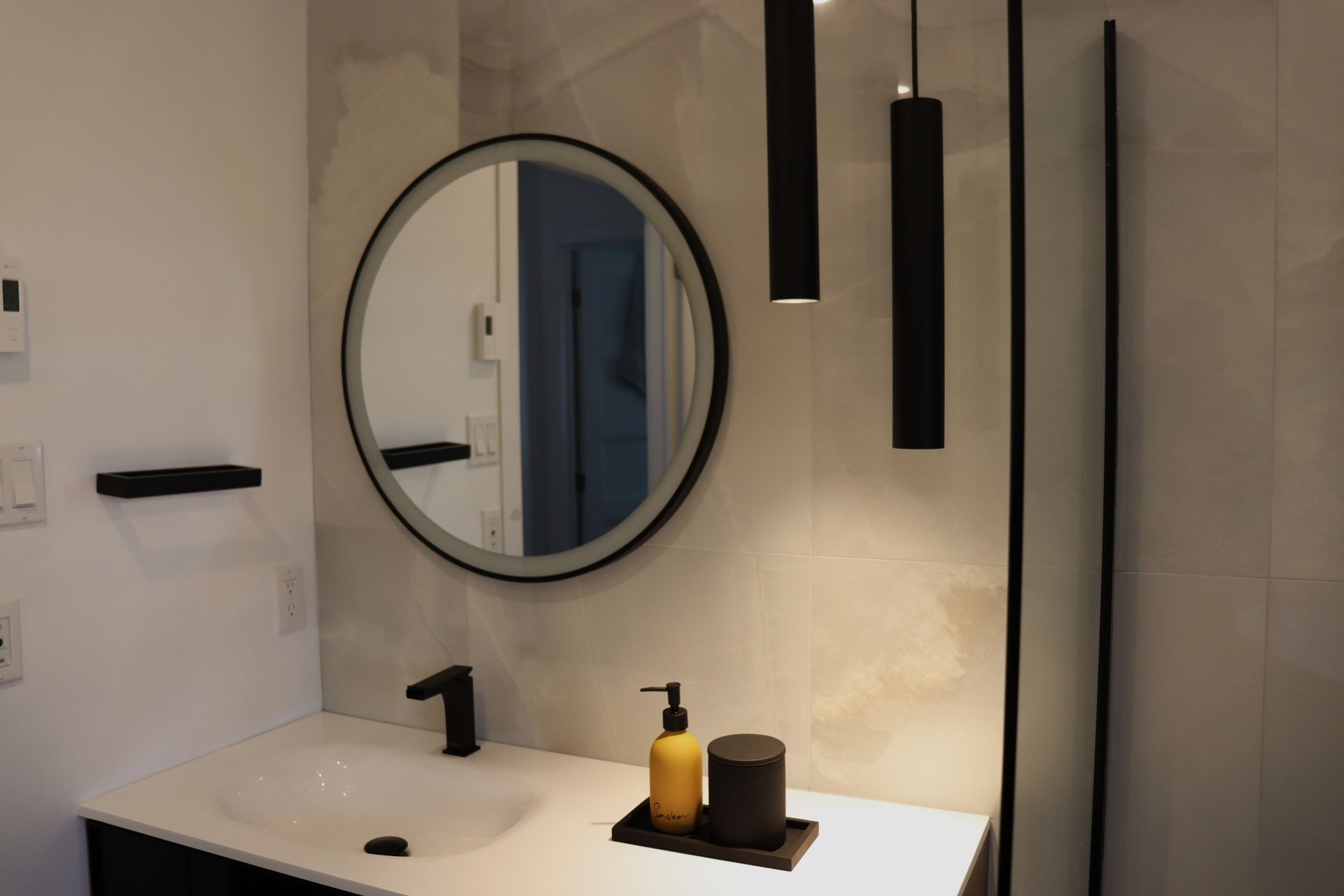 A bathroom with a sink , mirror and shower.