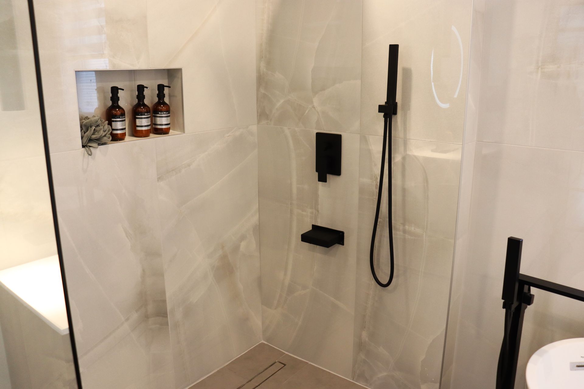 A bathroom with a walk in shower and a sink.