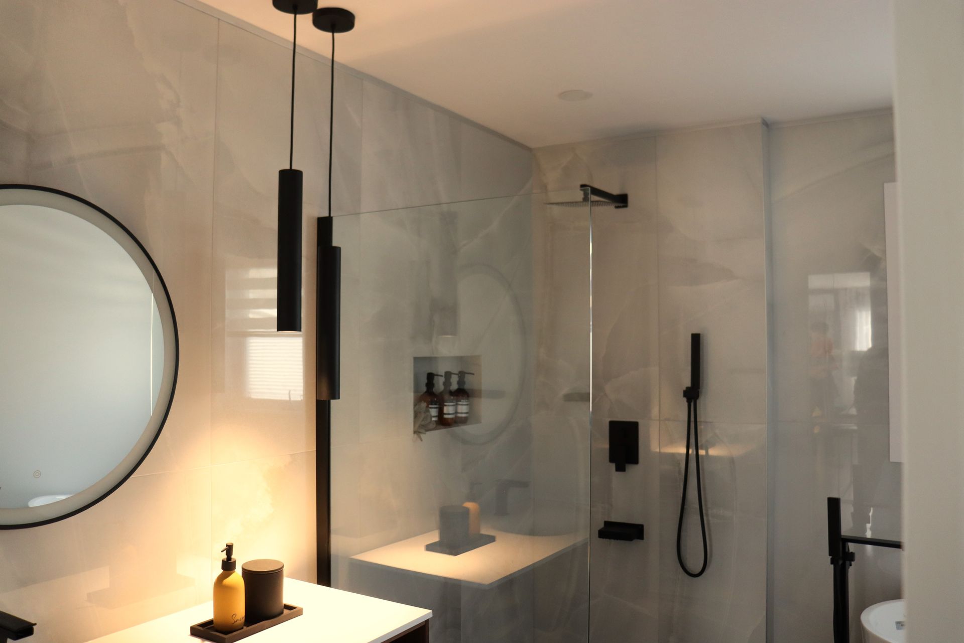 A bathroom with a sink , mirror and shower.