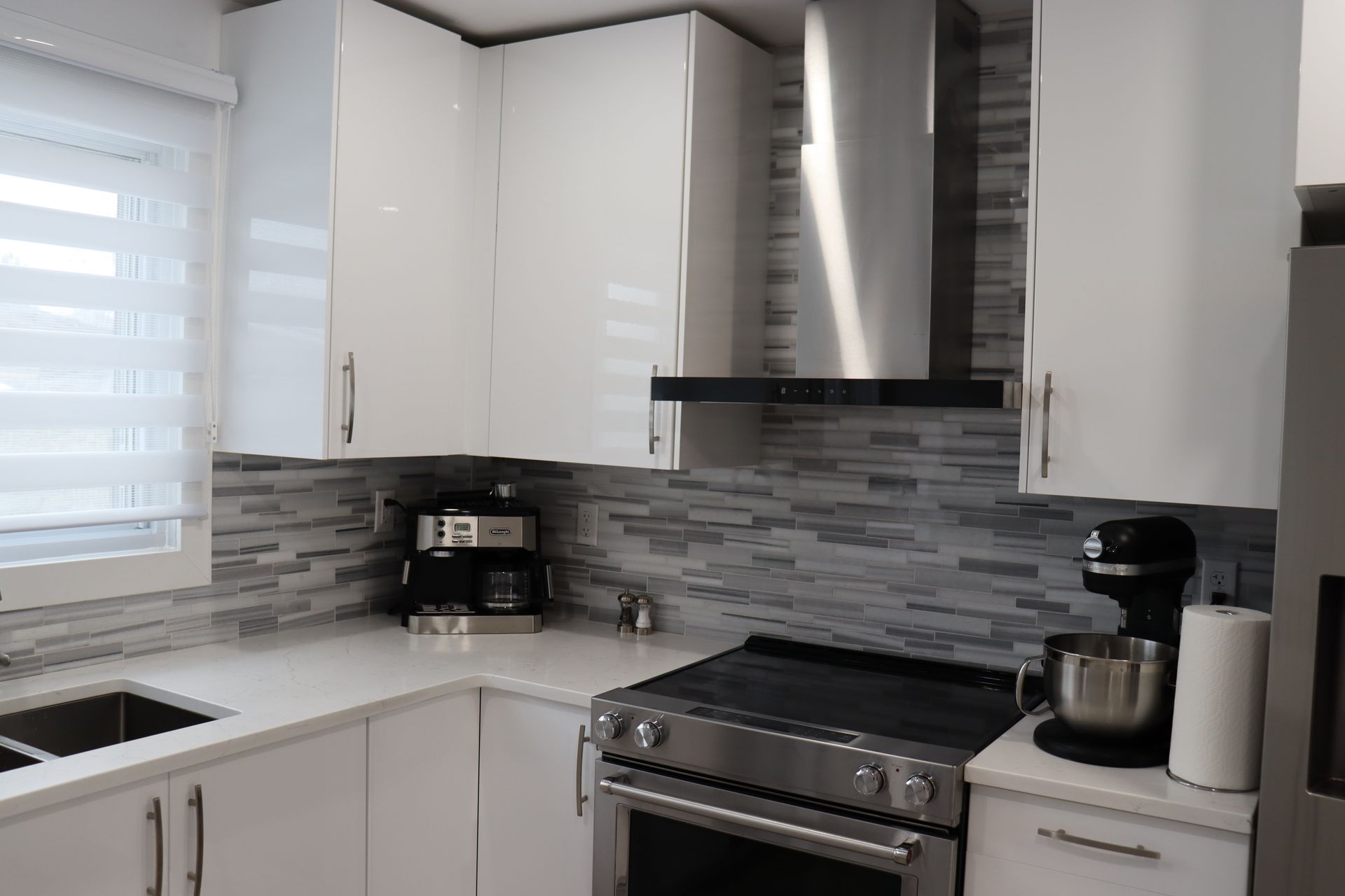 A kitchen with white cabinets and stainless steel appliances.