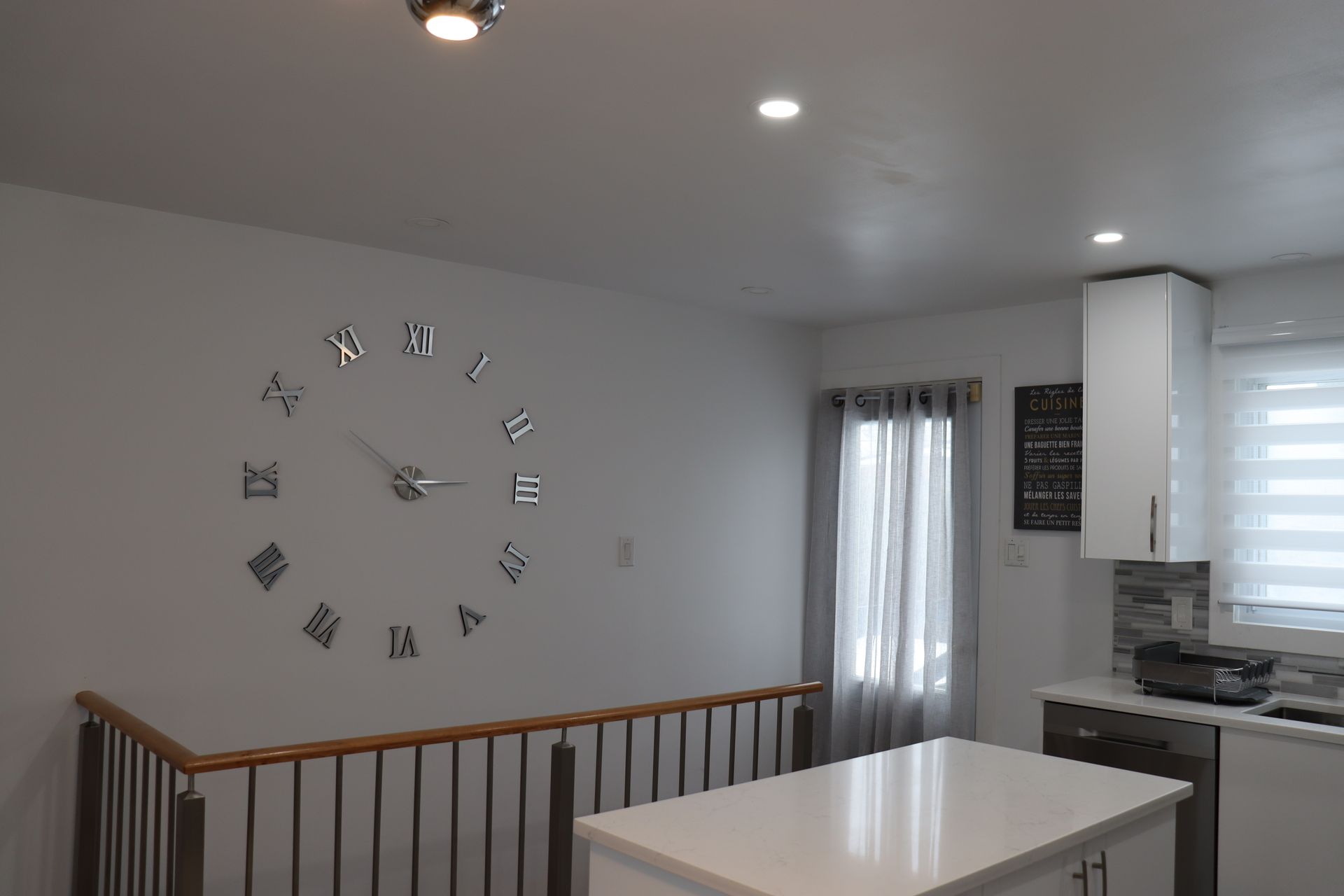A kitchen with a large clock on the wall.