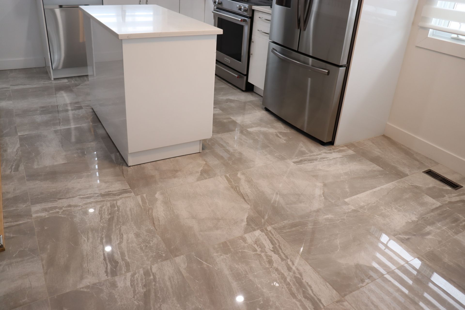 A kitchen with stainless steel appliances and a tiled floor.