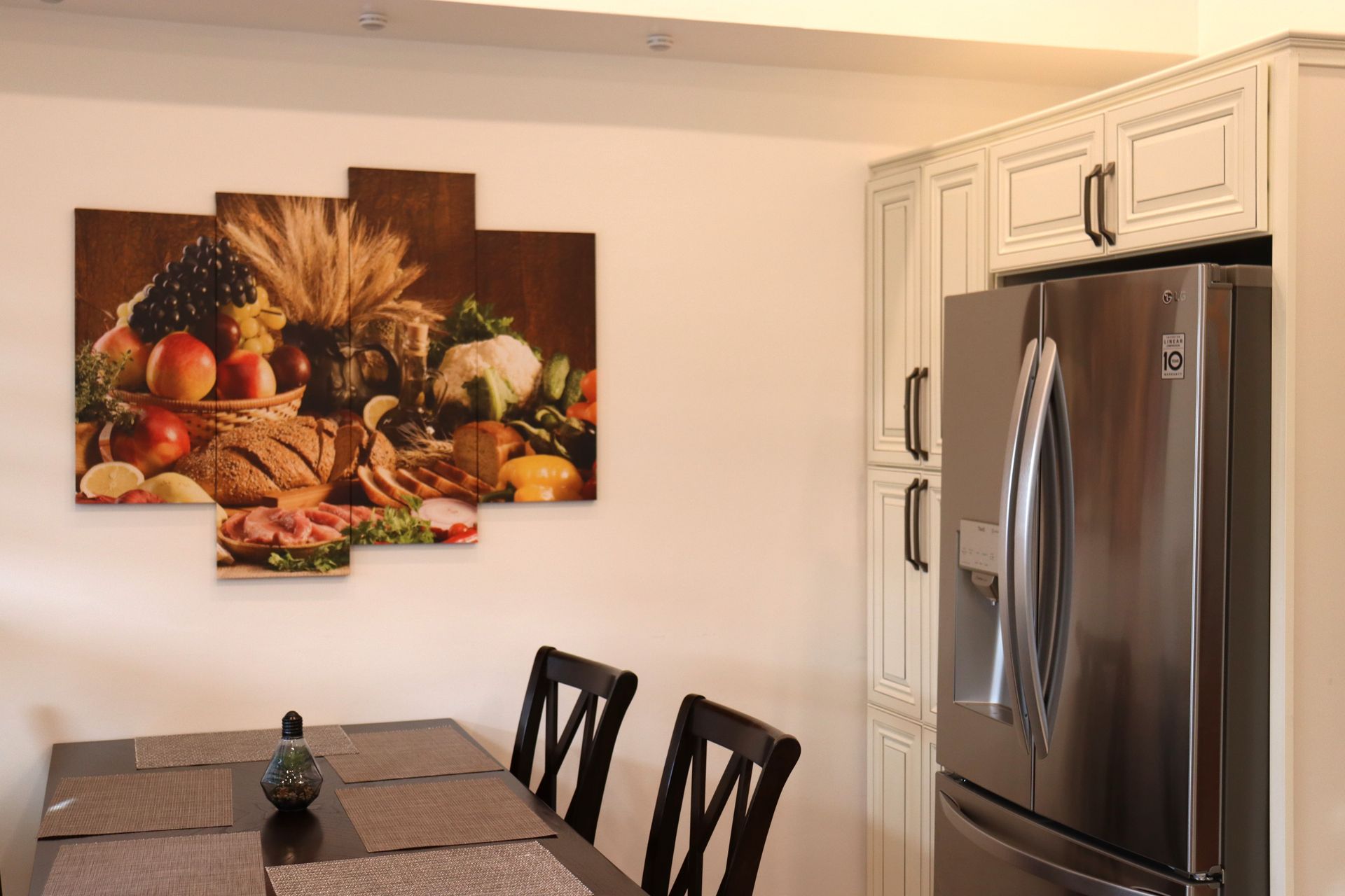 A kitchen with a table and chairs and a refrigerator