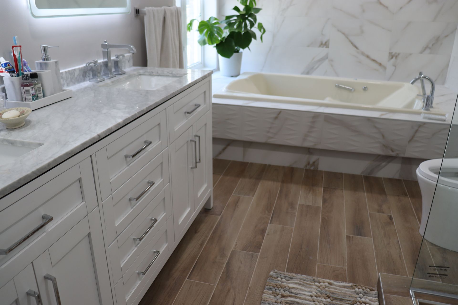 A bathroom with a tub , sink , toilet and mirror.