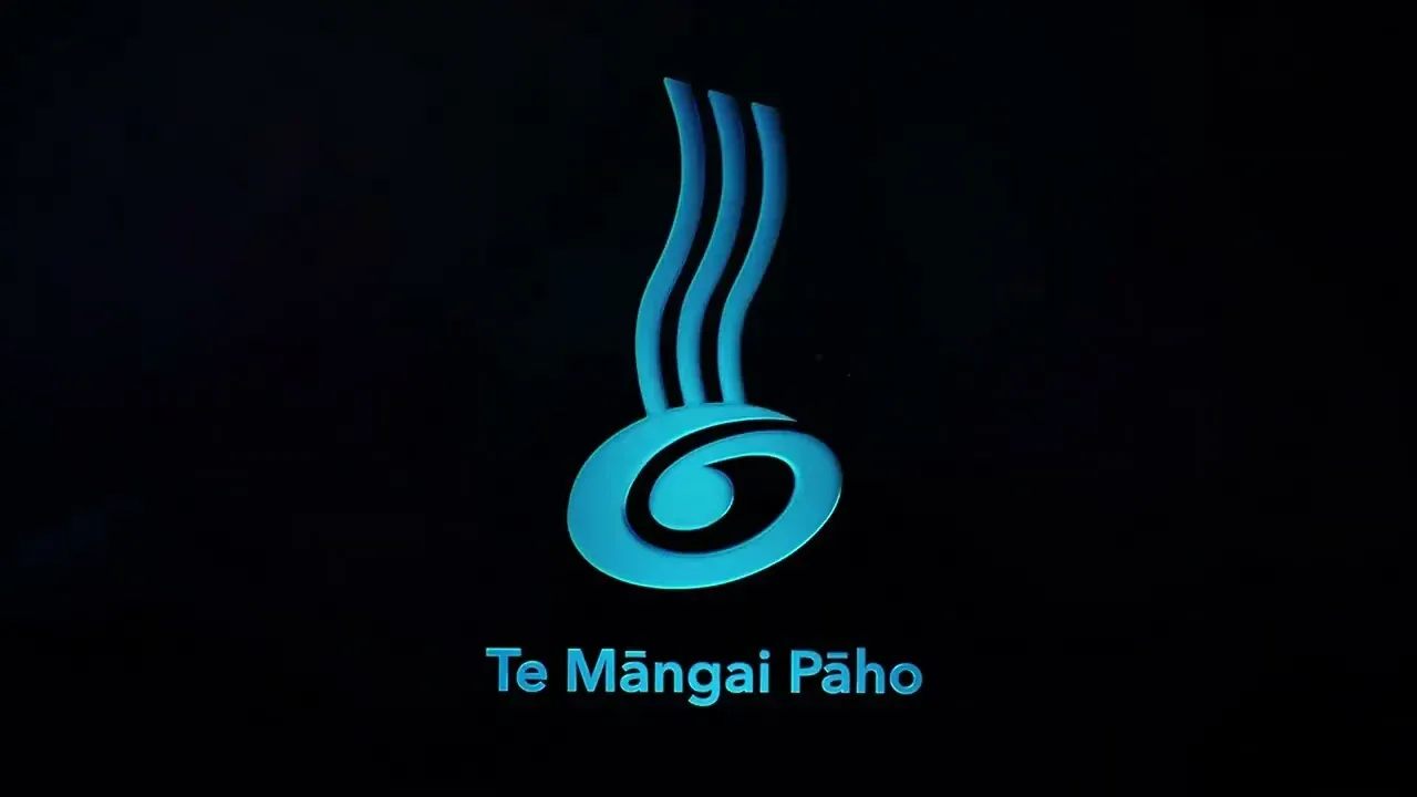 Blue glowing abstract logo on black background with the text “Te Mángai Pāho” below