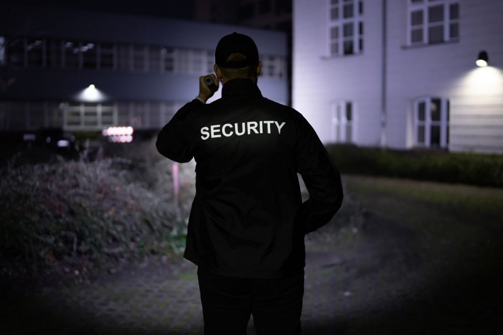 Security Guard Walking Building Perimeter With Flashlight At Night - Security Company in Quirindi, NSW