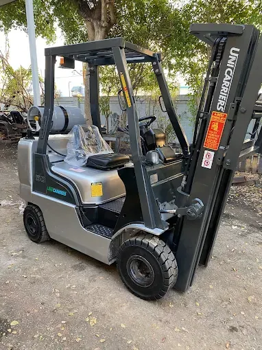 Silver forklift on pavement, outdoors.