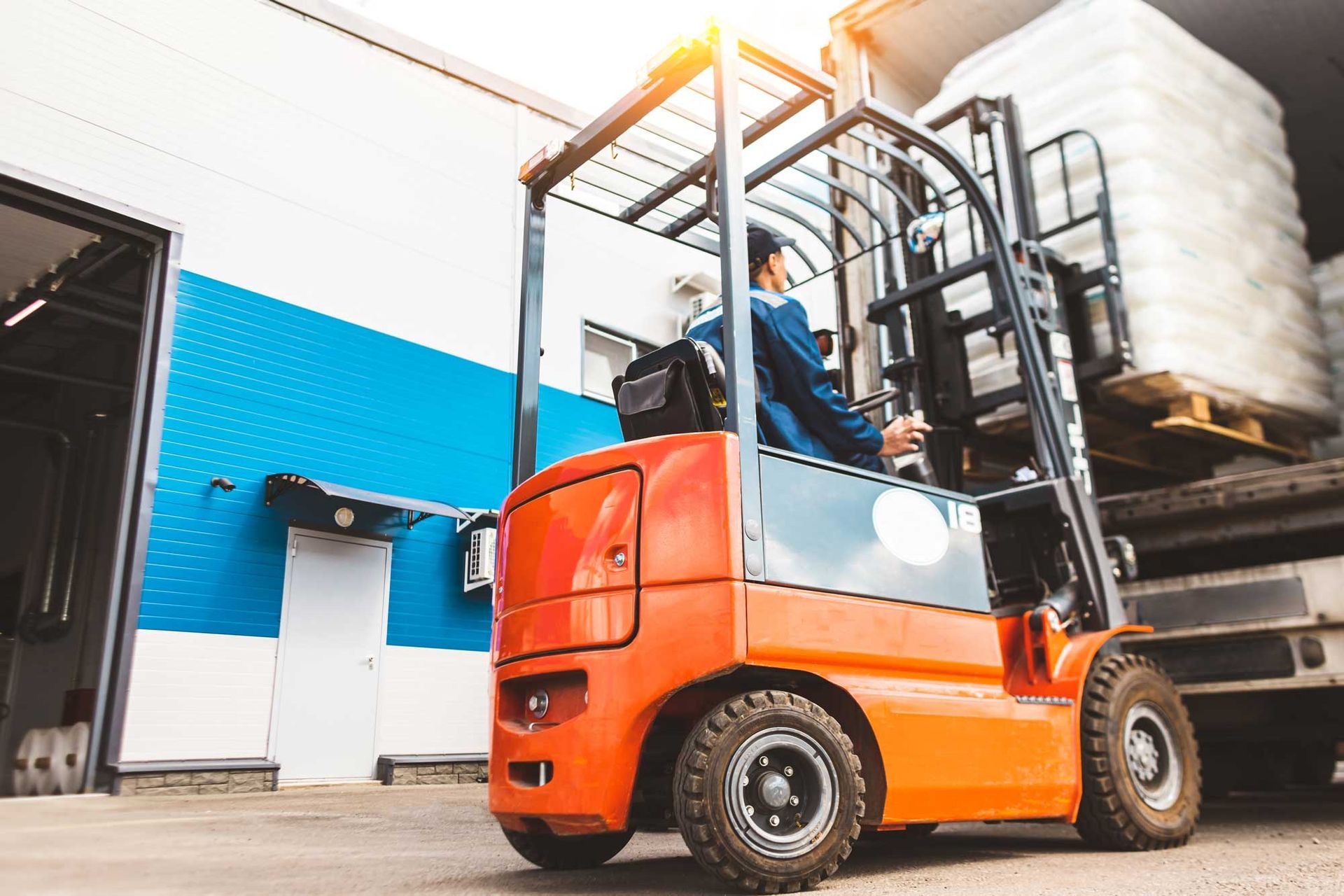 Forklift operator in a warehouse, wearing safety gear. Forklift operator in a warehouse, wearing safety gear.