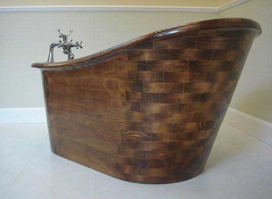 A wooden bathtub is sitting on the floor in a bathroom.