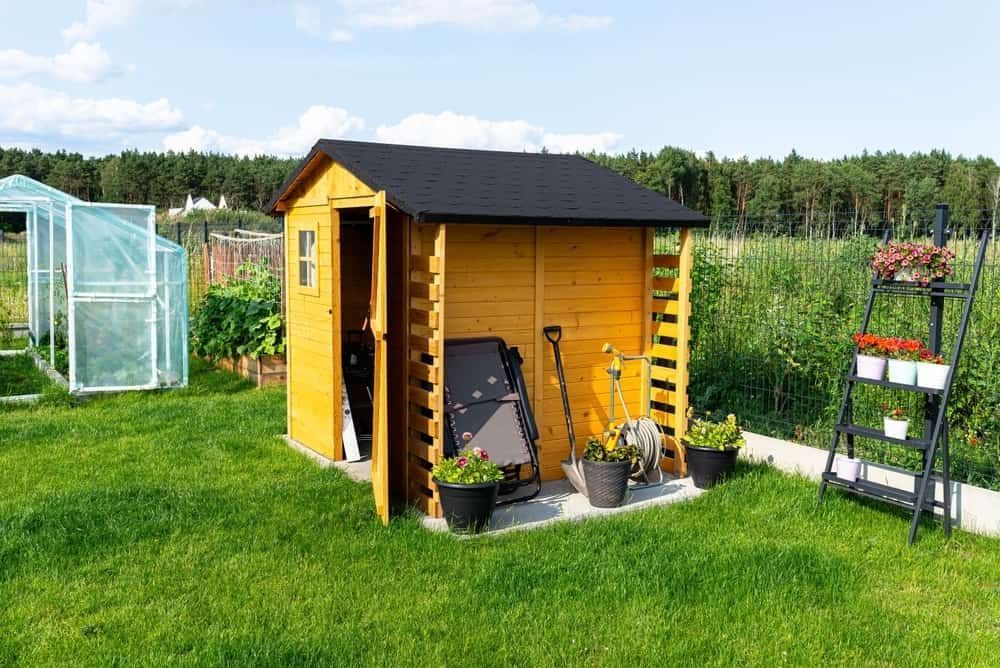 Wooden Shed With Open Door, Garden Tools, and Flowerpots in a Sunny Backyard — ShedBoss in Ravenshoe, QLD 
