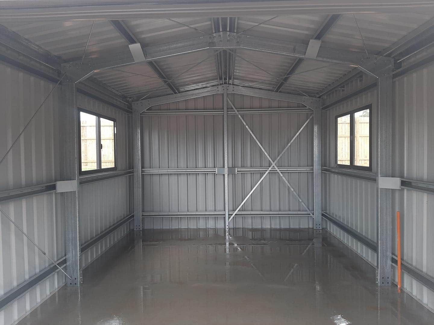 Interior of a Metal Shed With Two Windows and a Closed Door, the Floor Covered in Water — ShedBoss in Mareeba, QLD 