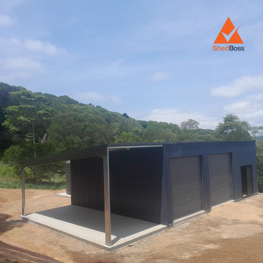 A Dark Gray Shed With Roller Doors and a Concrete Slab — ShedBoss in Atherton, QLD