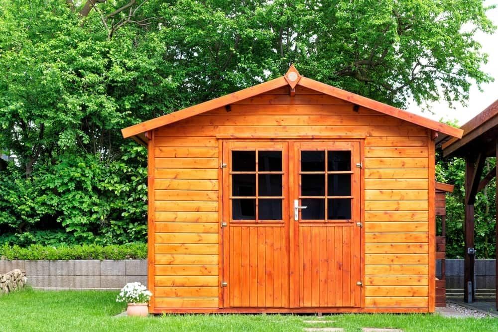 Wooden Shed With Double Doors, Set in a Grassy Yard Against a Backdrop of Green Foliage — ShedBoss in Ravenshoe, QLD 