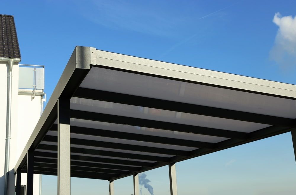 Gray Carport Structure With Horizontal Beams, Set Against a Blue Sky — ShedBoss in Tolga, QLD