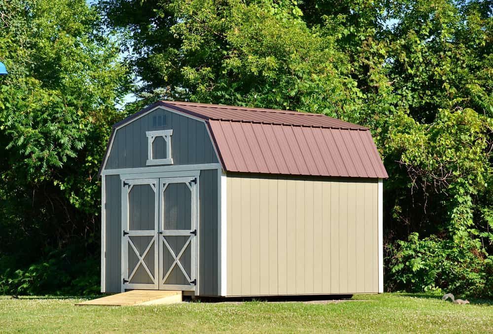 Tan and Blue Shed With Brown Roof in Front of Green Trees — ShedBoss in Ravenshoe, QLD 