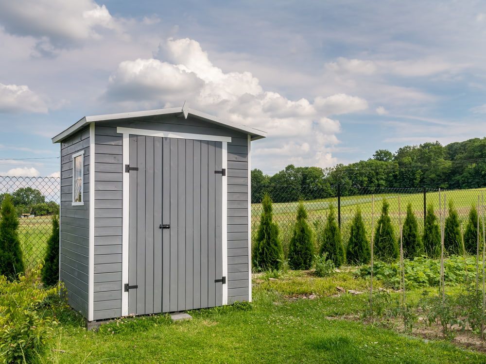 Gray Wooden Storage Shed in a Grassy Yard — ShedBoss in Atherton, QLD