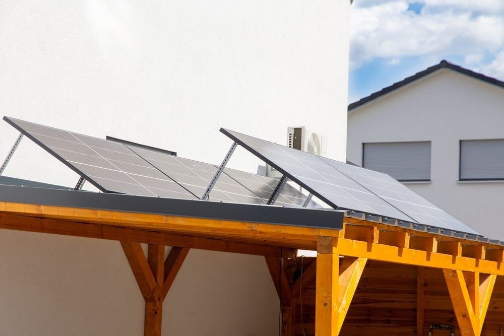 Solar Panels on a Wooden Carport Attached to a White Building — ShedBoss in Ravenshoe, QLD 
